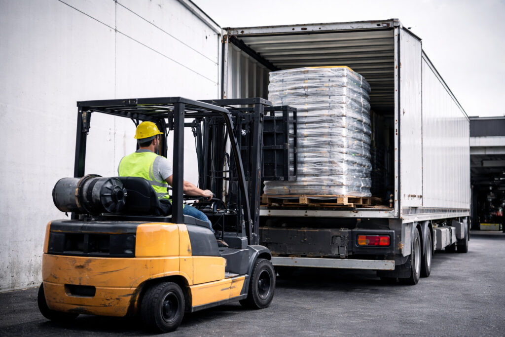 operaio con muletto che carica un pallet di plastica